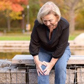 older woman holding her knee in pain   