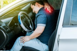 man touching his back after a car accident