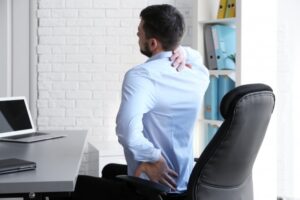 man sitting at a desk with back pain